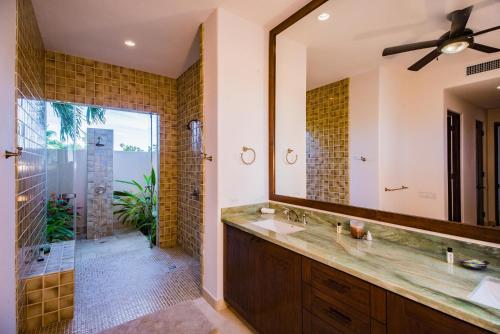 a bathroom with a large mirror and a sink at Villa de Suenos by Cabo Villas in San José del Cabo