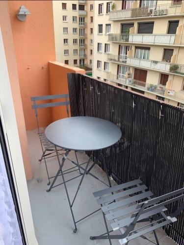 - un balcon avec une table et des chaises dans l'établissement Appartement charmant dans une résidence calme, à Perpignan