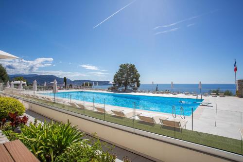 une piscine avec des chaises et l'océan en arrière-plan dans l'établissement ALTAIR AP4466 by RIVIERA HOLIDAY HOMES, à Nice
