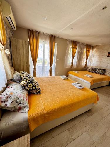 a bedroom with two beds and a window at Apartments Tadic in Petrovac na Moru