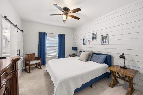 a bedroom with a bed and a ceiling fan at Hill Country Hideout in FBGTX in Fredericksburg