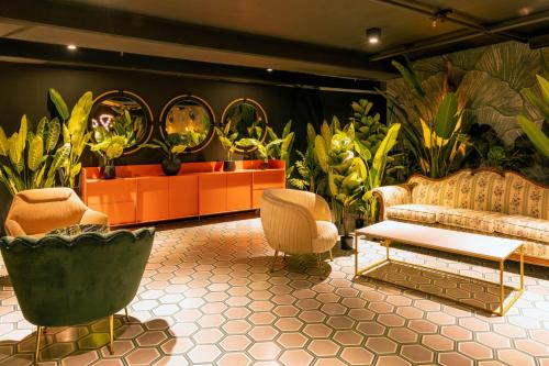 a living room with a couch and some plants at Lux at 15, Pool, Gym and Stylish City Stay in Hatillo