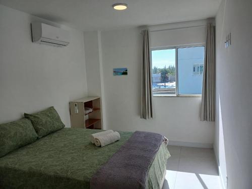 una camera da letto con un letto verde e una finestra di Golden Lake - Lazer e Conforto ad Arraial do Cabo