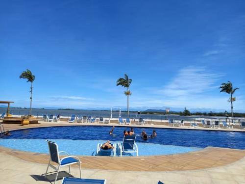una piscina con persone sedute su sedie in acqua di Golden Lake - Lazer e Conforto ad Arraial do Cabo