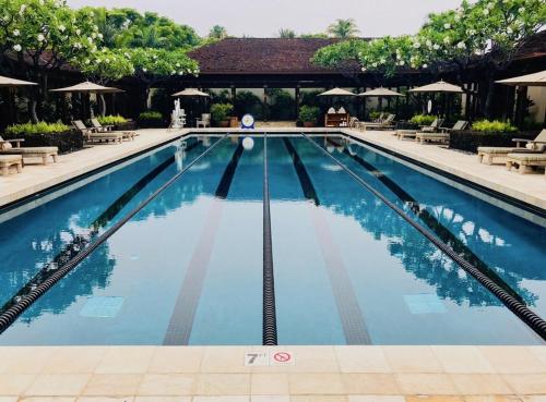 a swimming pool at a resort with tables and chairs at 3BD Hainoa Villa (2907C) at Hualalai Resort in Kukio