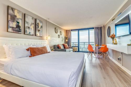 a bedroom with a large bed and a living room at Stunning Oceanfront Studio Suite, Dogs OK! 1228 in Myrtle Beach