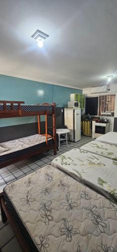 a room with two bunk beds and a kitchen at Pousada Temporada Maceió in Maceió