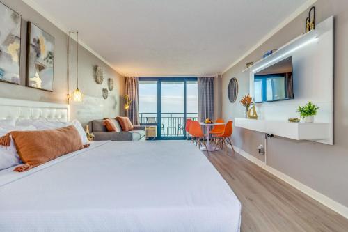 a bedroom with a large bed and a living room at WINTER RATES! Stunning Oceanfront Studio Suite, Dogs OK! 1228 in Myrtle Beach
