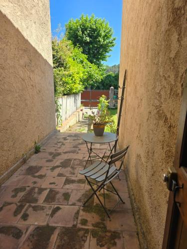 een tafel en stoelen op een stenen patio bij L'Orée du Loup in La Colle-sur-Loup