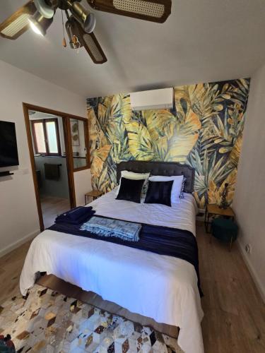 een slaapkamer met een groot bed met tropisch behang bij L'Orée du Loup in La Colle-sur-Loup
