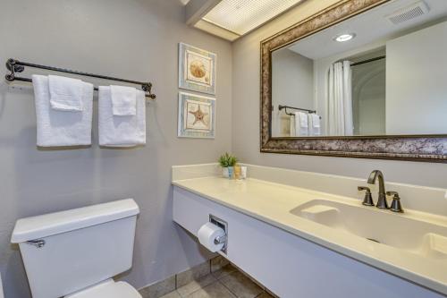 a bathroom with a sink and a toilet and a mirror at WINTER RATES! Stunning Oceanfront Studio Suite, Dogs OK! 1228 in Myrtle Beach