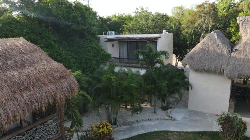 a building with a thatched roof and a yard at Villa AHAL, in Chemuyil