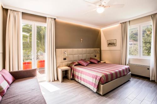 a bedroom with a bed and a couch at Hotel Sorriso in Toscolano Maderno