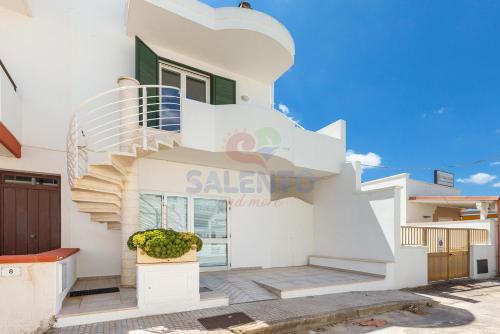 a white house with a spiral staircase on it at Salentoandmore-Stella del mare in Torre Pali