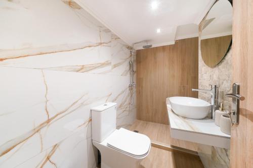 a bathroom with a white toilet and a sink at Emmas House in Panayia