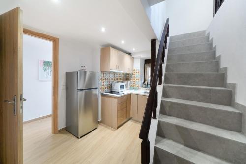 a kitchen with a staircase and a stainless steel refrigerator at Emmas House in Panayia