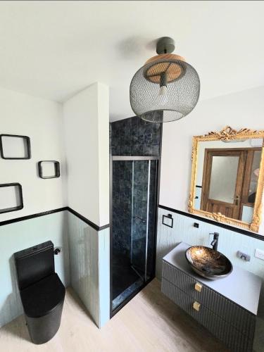 une salle de bain avec un lavabo, des toilettes et un miroir dans l'établissement L'Orée du Loup, à La Colle-sur-Loup