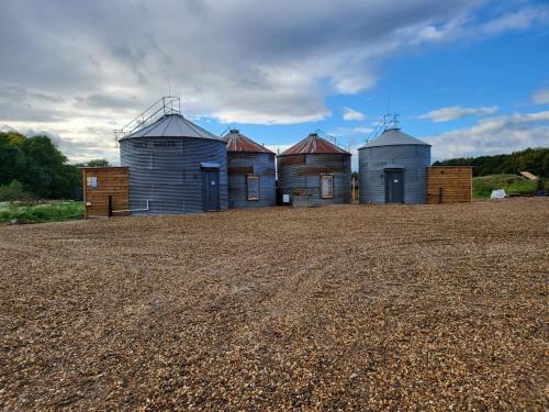 a row of grain silos in a field at The Stables & Silos in Braintree