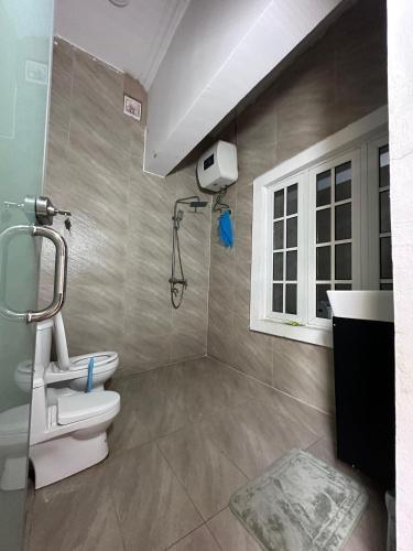 a bathroom with a shower and a toilet and a window at The Boutique apartments in Abuja