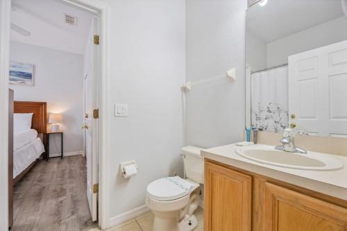 a white bathroom with a toilet and a sink at Cozy Stylish Townhome in Davenport