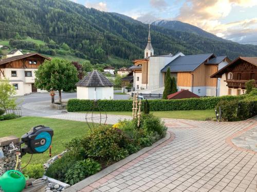 a small village with a church and a street at Gästehaus Köll in Roppen
