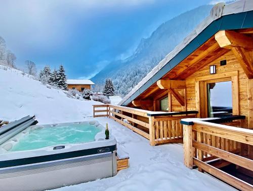 a hot tub in the snow next to a cabin at Chalet Asgard in Morzine