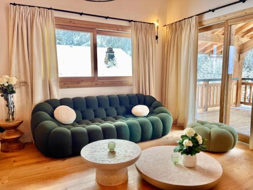 a living room with a blue couch and two tables at Chalet Asgard in Morzine