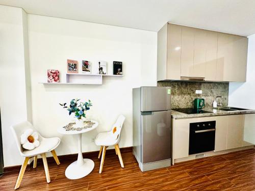 a kitchen with a table and chairs and a refrigerator at Studio VIP Luxury Masteries OCP1 in Gia Lâm Pho