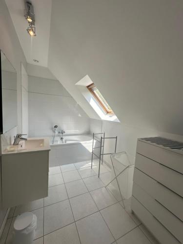une salle de bain blanche avec un lavabo et une baignoire dans l'établissement Détente & Horizon, à Cully