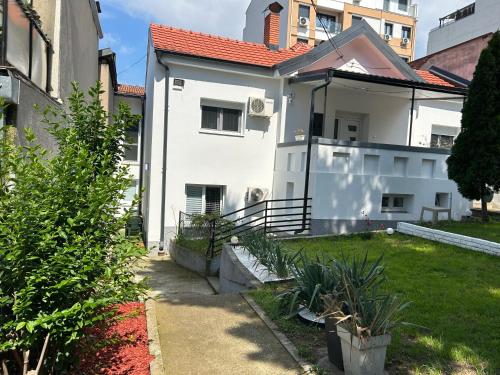 a white house with a red roof at Magenta Garden in Belgrade
