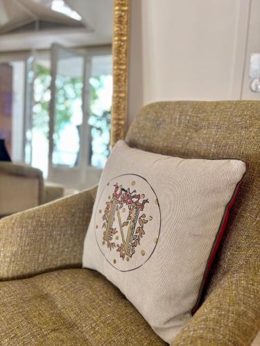 a pillow sitting on a couch with a insignia on it at Maison Bonaparte in Bastia
