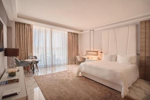 a bedroom with a large white bed and a desk at Marchica Lagoon Resort in Nador