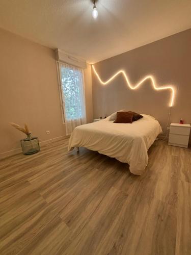 une chambre avec un lit avec une tête de lit éclairée dans l'établissement Appartement T3 Avignon, proche centre-ville, à Avignon