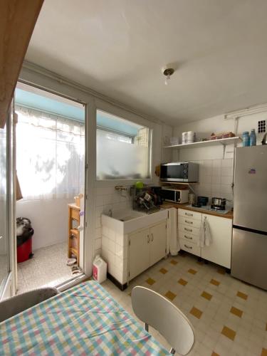 Il comprend une cuisine équipée d'un réfrigérateur, d'une table et de chaises. dans l'établissement Appartement vue mer, à Marseille