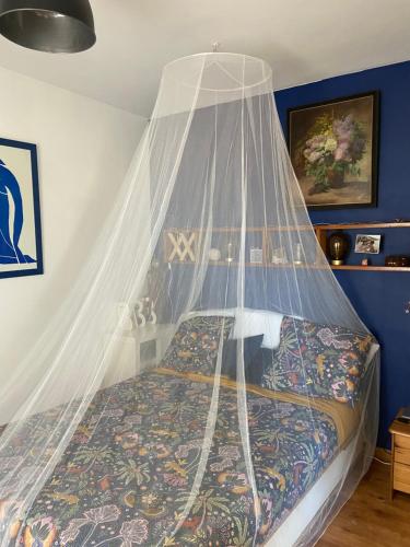 Cette chambre comprend un lit à baldaquin. dans l'établissement Appartement vue mer, à Marseille