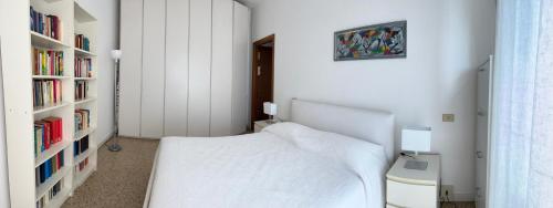 a bedroom with a white bed and a book shelf at novarasanmartino22 in Novara