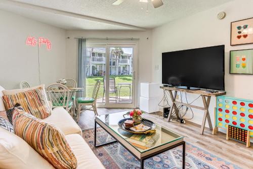 a living room with a couch and a flat screen tv at Sea La Vie Condo Pensacola Beach Access! in Pensacola Beach