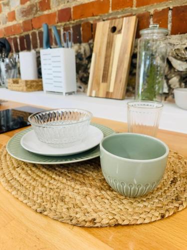 a table with two bowls and plates on a table at The Stables & Silos in Braintree