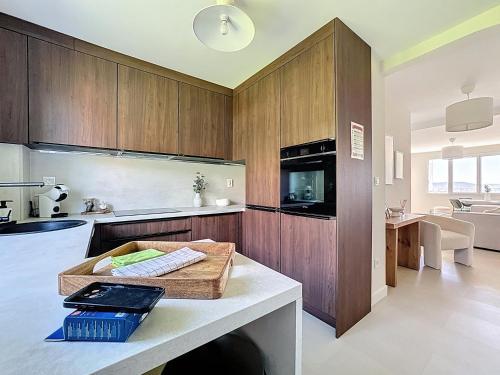 une cuisine avec des armoires en bois et un comptoir dans l'établissement Appartement clair et lumineux, à Clermont-Ferrand