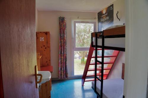 une chambre avec un lit superposé et une fenêtre dans l'établissement Auberge de Jeunesse HI Belle-Île-en-Mer, au Palais