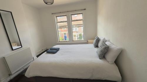 a white bed in a room with a window at Spacious room 3 in Bristol