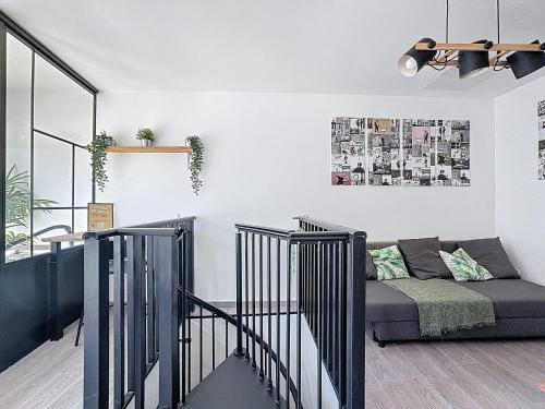 un salon avec un canapé et un escalier dans l'établissement Appartement 2 niveaux charme & confort, à Clermont-Ferrand