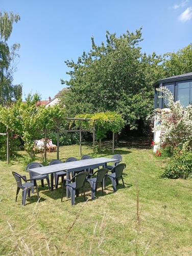 a group of tables and chairs in the grass at Gite "Chez Eléonore et Axel" in Gouvieux