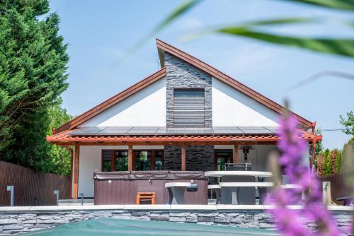 a house with a pool in front of it at Bonovo Wellness Nyaraló in Gyomaendrőd