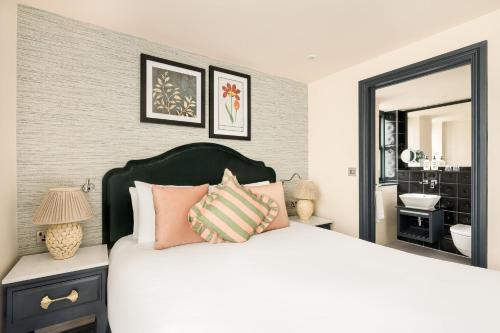 a bedroom with a large white bed with pink pillows at Hotel Indigo London - Kensington by IHG in London