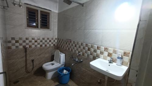 a bathroom with a toilet and a sink at Sugarcane Homestay in Attigundi