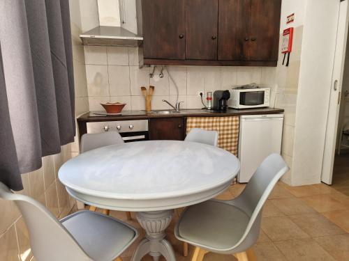 a white table and chairs in a small kitchen at Casa Gil Vicente in Évora