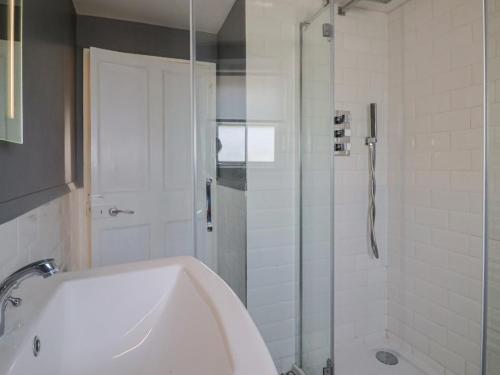 a bathroom with a shower and a tub and a sink at Sea Holly in Lyme Regis