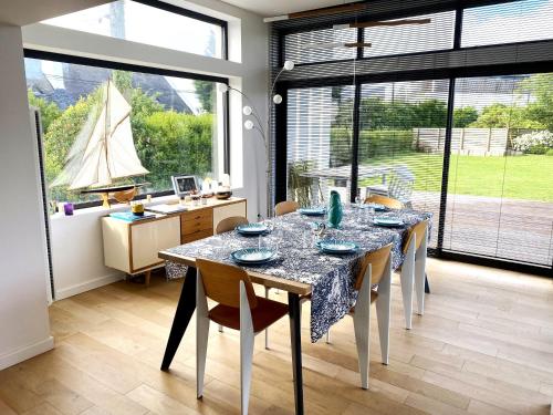 une salle à manger avec une table et un bateau à la fenêtre dans l'établissement Villa de la Pointe, à Saint-Pabu