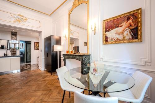 une salle à manger avec une table en verre et des chaises blanches dans l'établissement Appartement Belle Époque cœur de ville -AC-, à Nice